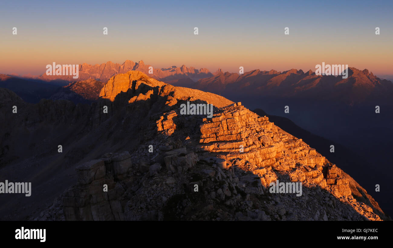 Alpenglow sul Latemar montagna del massiccio al tramonto. Il Trentino Dolomiti. Sullo sfondo le Pale di San Martino e il Lagorai. Alpi italiane. Foto Stock