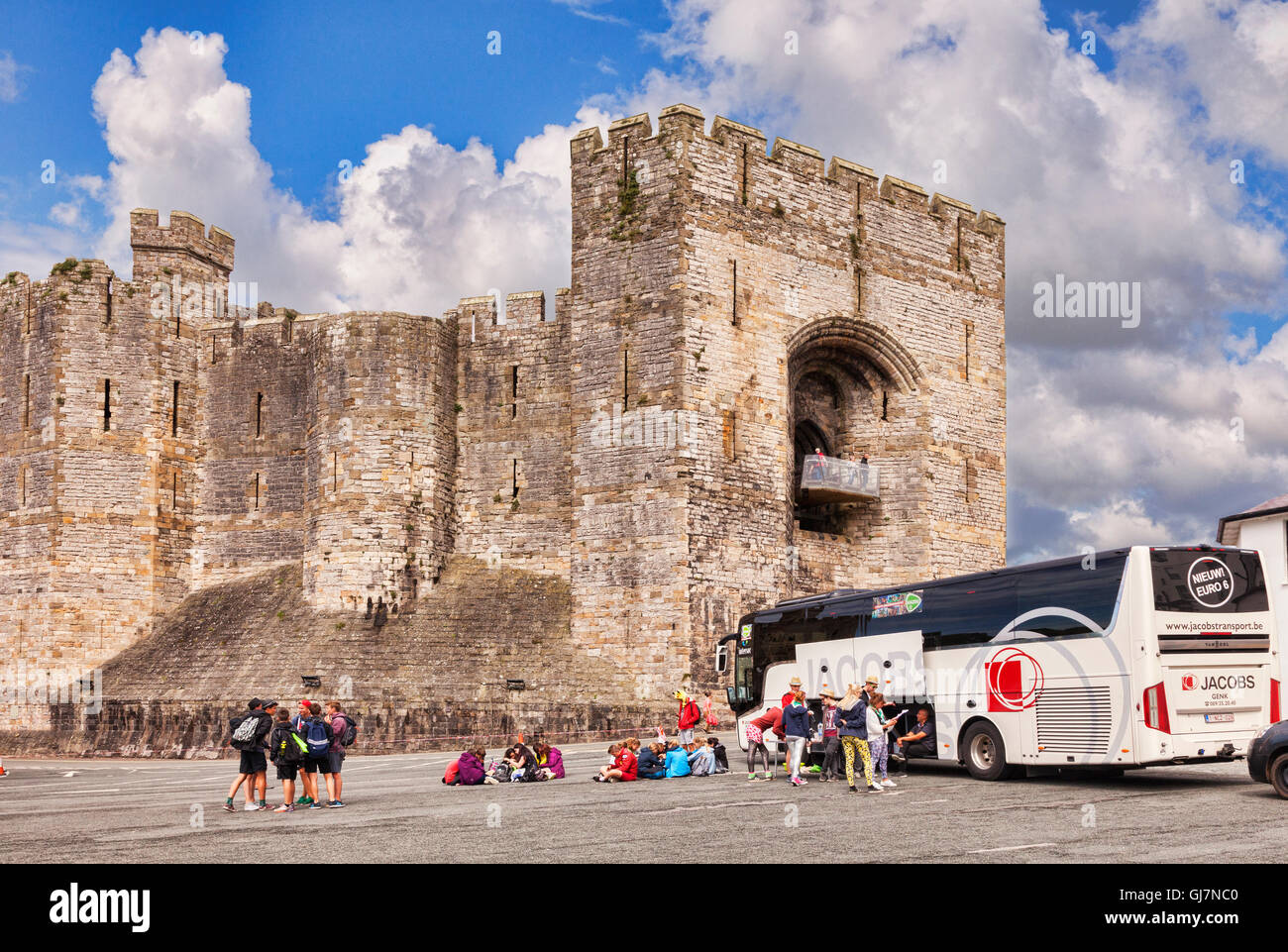 Turisti e tour in pullman a Caernarfon Castle, Gwynedd, Wales, Regno Unito Foto Stock