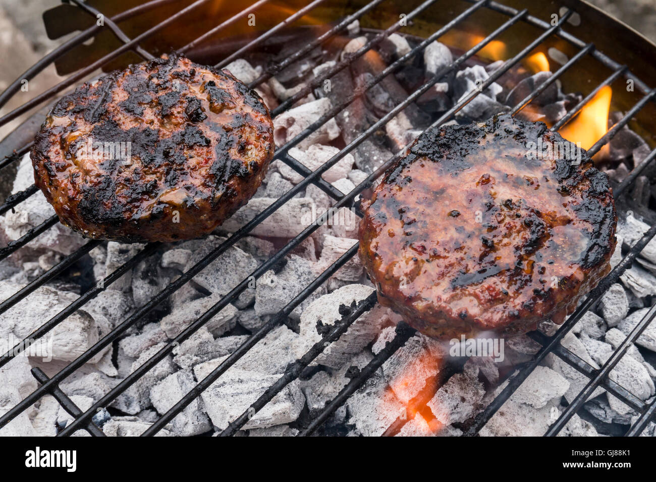 Hamburger cottura su un barbecue grill Foto Stock