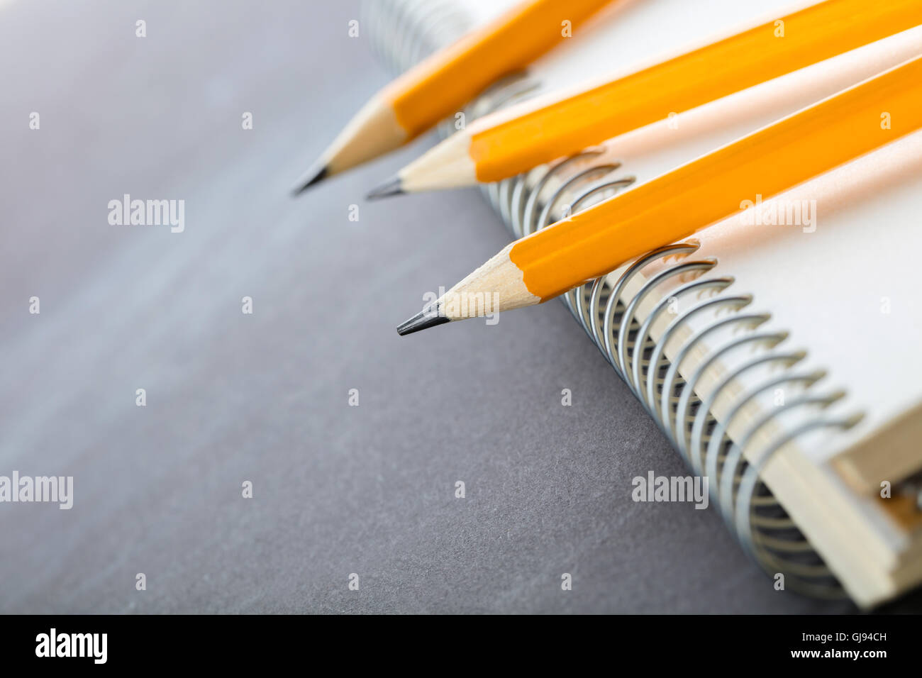 Affilare matite e un notebook su sfondo scuro Foto Stock