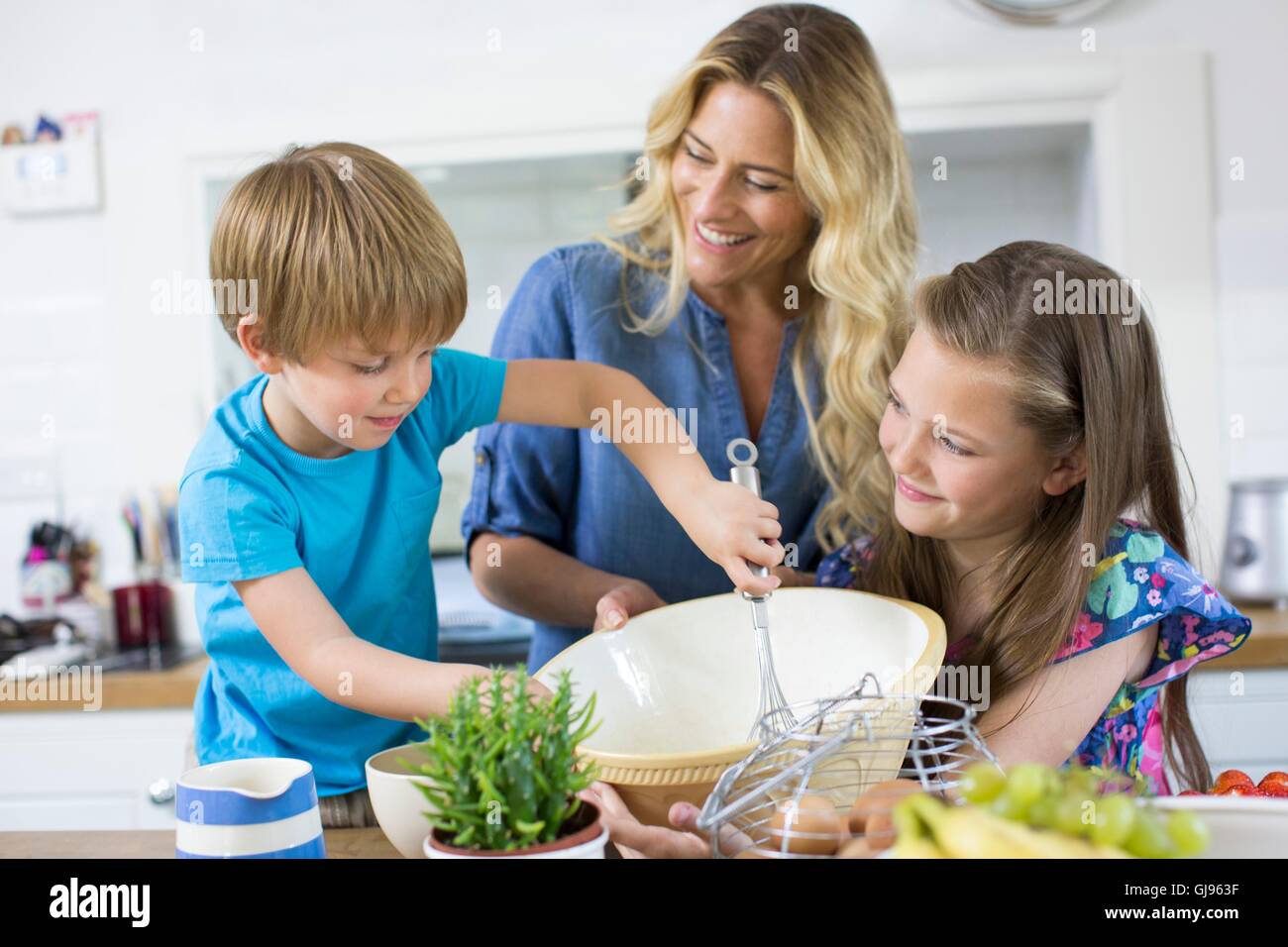 Proprietà rilasciato. Modello rilasciato. La madre e il figlio e la figlia cucina in cucina. Foto Stock