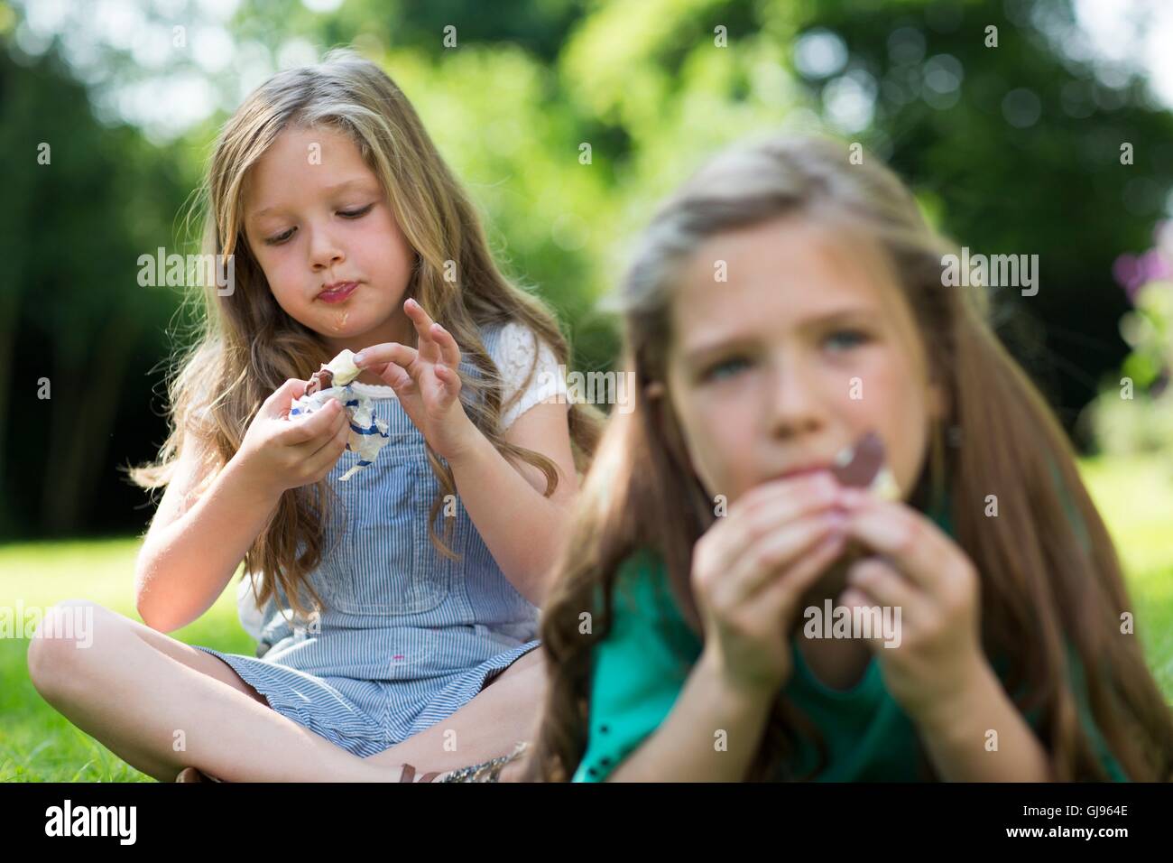 Proprietà rilasciato. Modello rilasciato. Le ragazze di mangiare gelati in giardino. Foto Stock