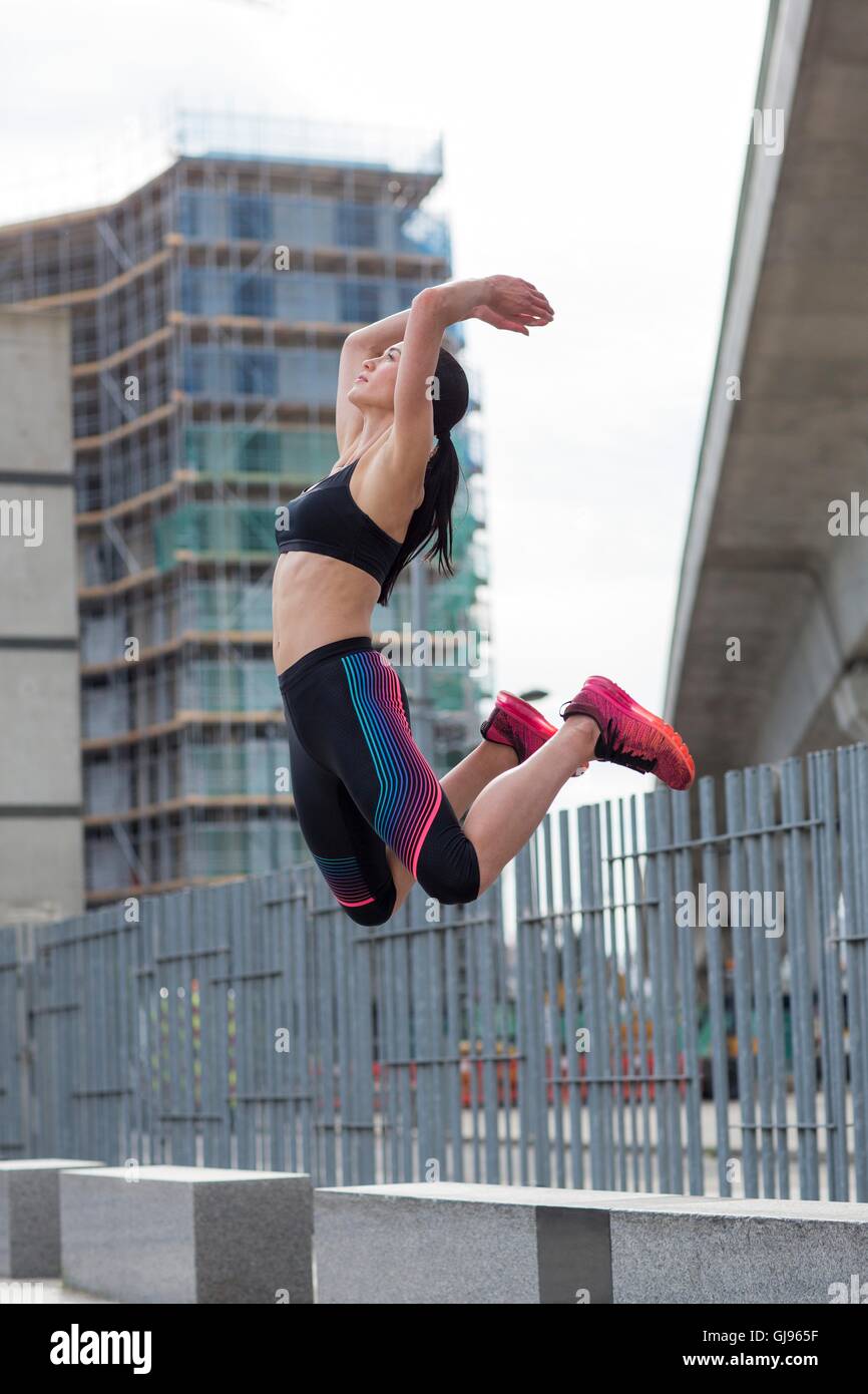 Modello rilasciato. Giovane donna jumping metà dell'aria. Foto Stock