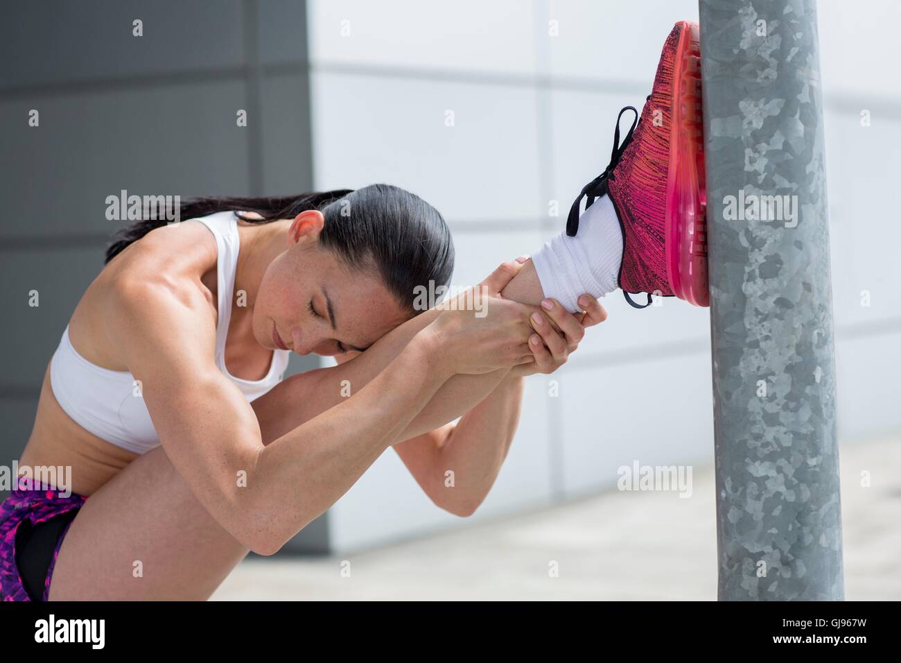 Modello rilasciato. Giovane donna lo stiramento dei muscoli delle gambe. Foto Stock