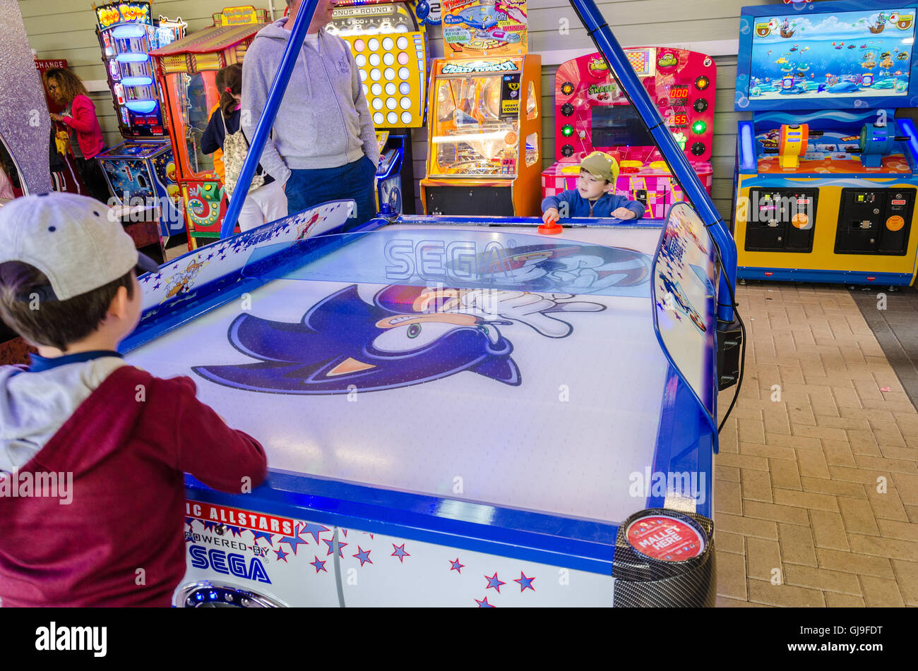 Due giovani fratelli giocare air hockey in una sala giochi. Foto Stock