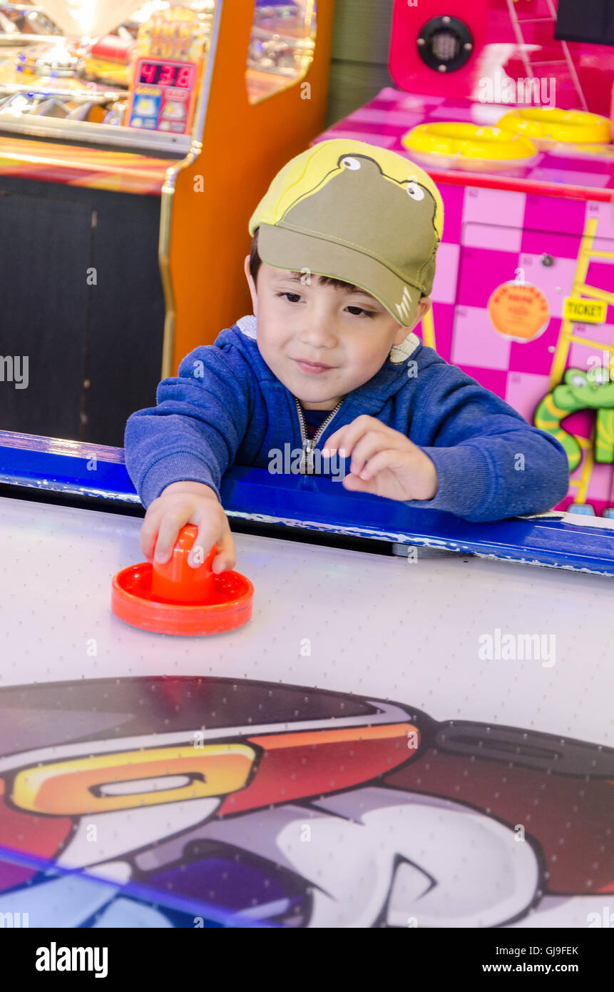 Un giovane ragazzo la riproduzione di aria in una sala giochi. Foto Stock