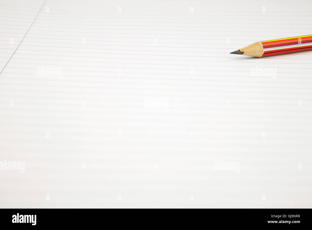 Close up di un fustellato white lined Notepad con una matita in arrivo Foto Stock