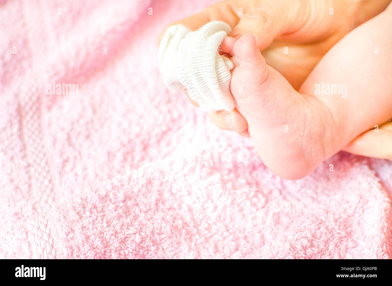 Mettere calze bianche a bebe Foto Stock
