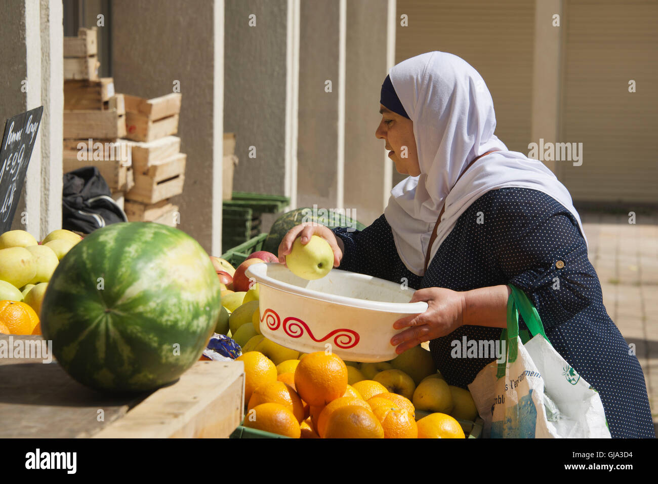 Donna musulmana la scelta di frutta sul mercato Apt Luberon Provence Francia Foto Stock