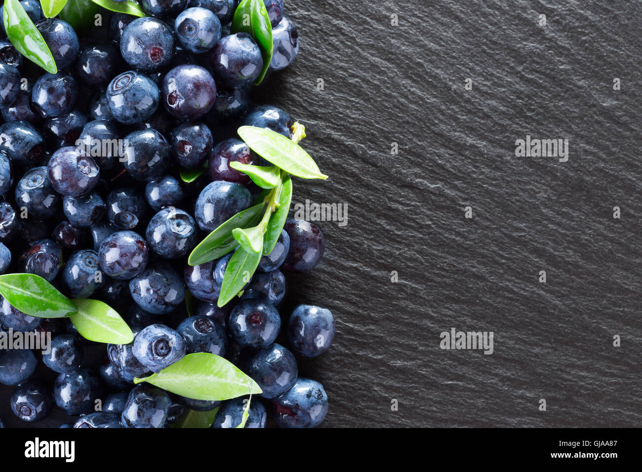 I mirtilli su una tavola di ardesia. Foto Stock I mirtilli su una tavola di ardesia. Foto Stock