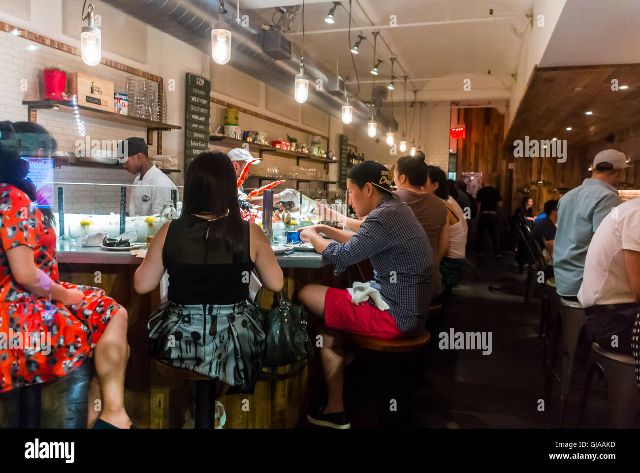 New York City, New York, Stati Uniti, turisti cinesi di grandi dimensioni, condivisione di pasti a base di pesce al ristorante Chelsea Market, tavoli da lavoro per donne di città, cucina asiatica Foto Stock