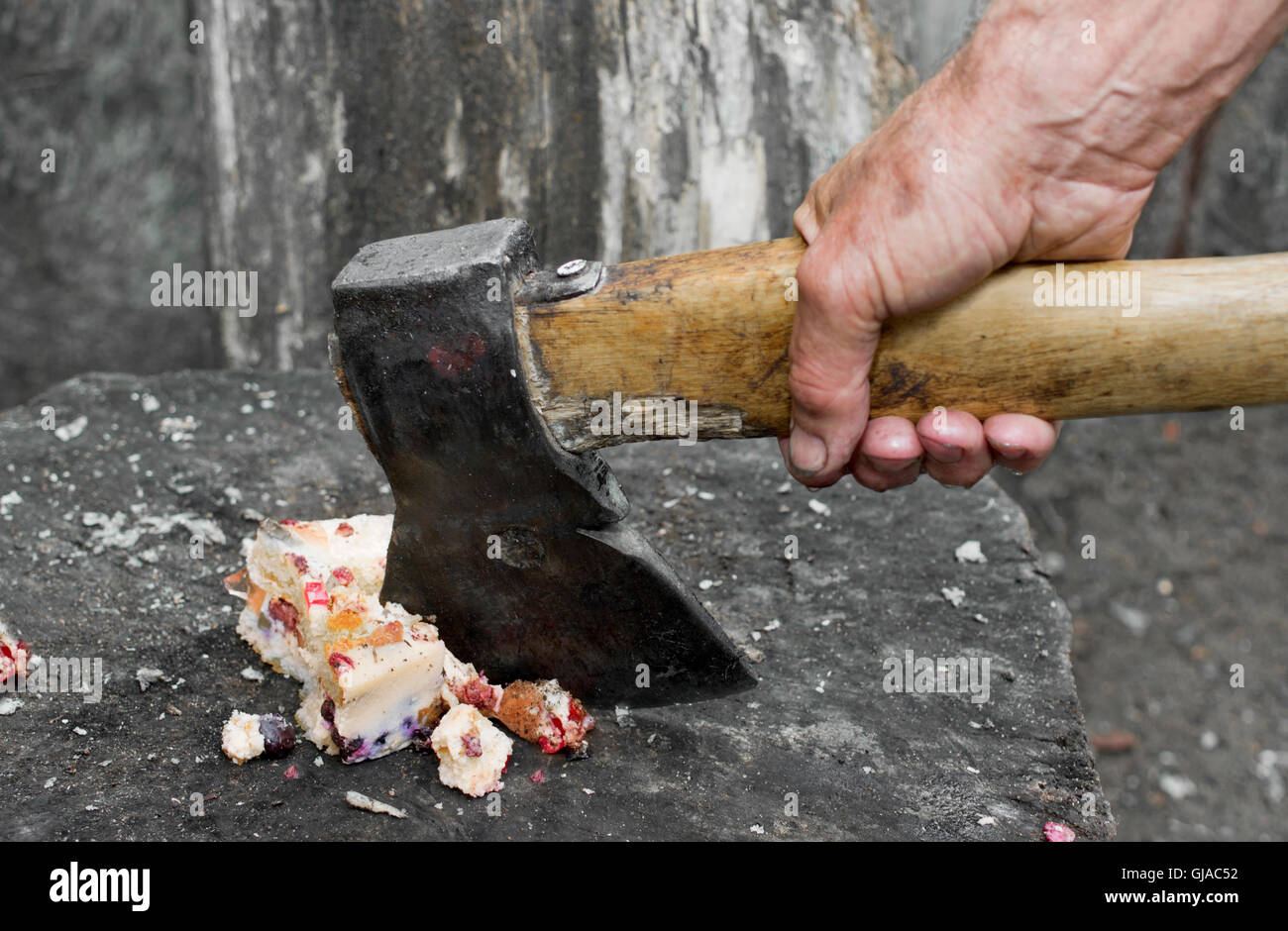 Butcher mano con ax tritare una torta di formaggio su un blocco di macellaio, closeup colpo all'aperto. Concetto di uscire da surriscaldamenti Foto Stock