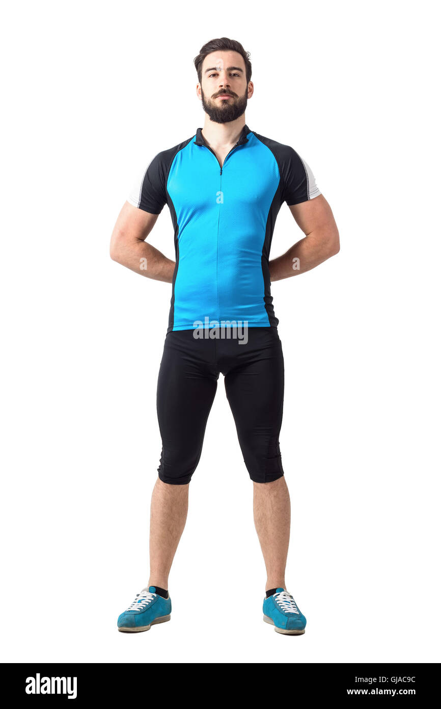 Orgogliosa forte ciclista sportivo nel ciclismo vestiti in piedi con le mani dietro la schiena. Corpo pieno lunghezza ritratto isolato su bianco Foto Stock