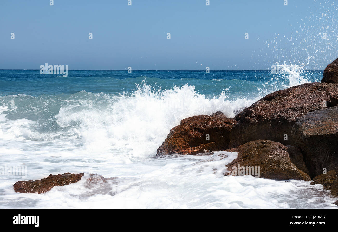 Seascape bianca di onde che si infrangono sulla luce solare marrone rocce shot per Sky ad essere utilizzata come spazio di copia Foto Stock