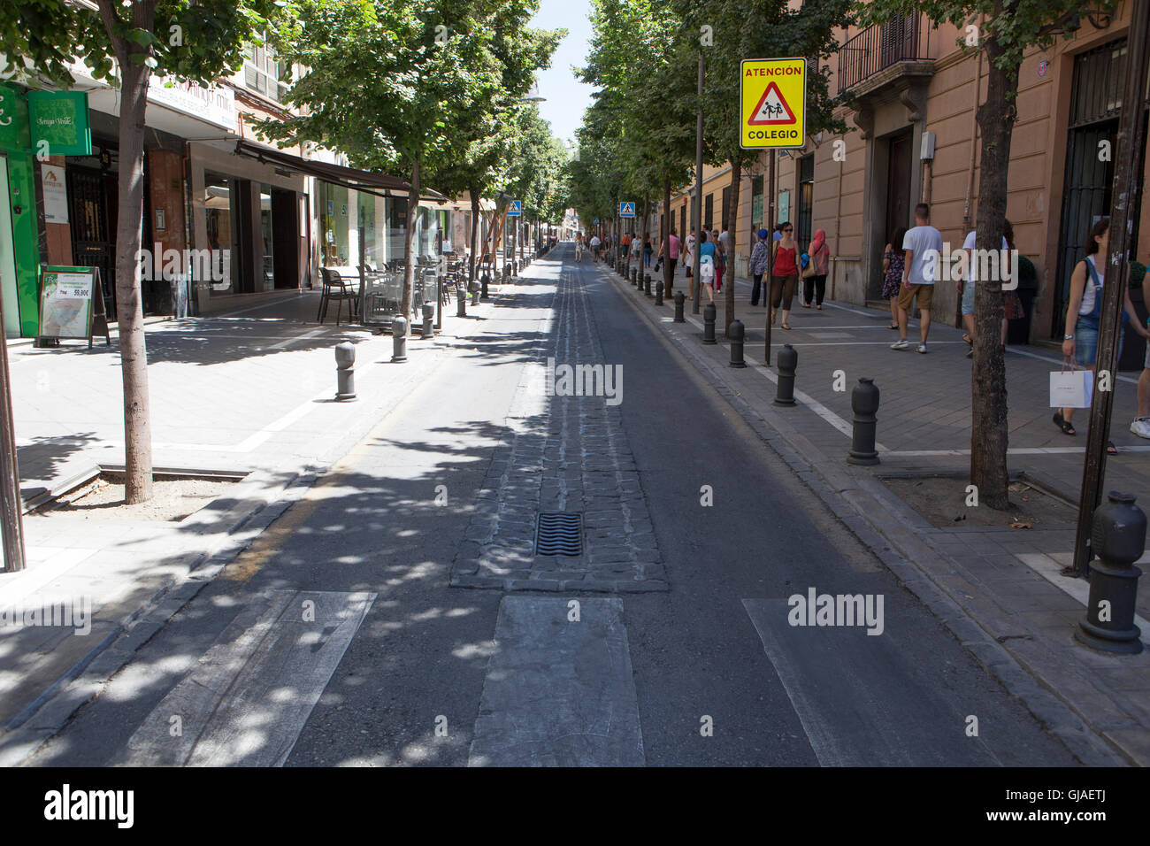 Granada, Spagna - 5 Agosto 2016: city centre street un caldo giorno d'estate con la gente che camminava sul marciapiede in ombra Foto Stock