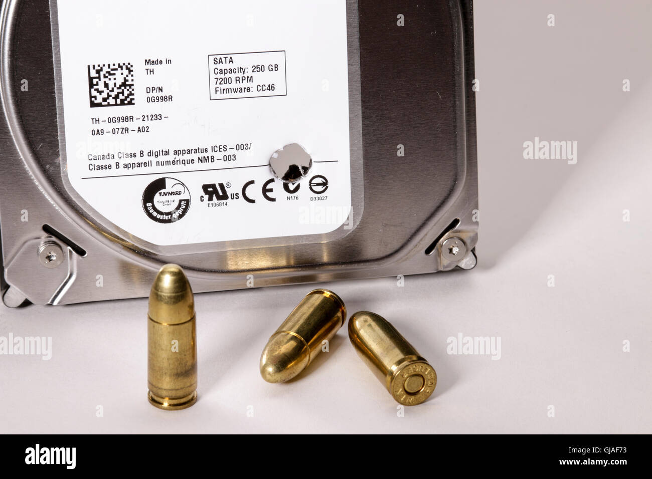 Unità disco rigido del computer con foro di proiettile e 9mm proiettili. Foto Stock
