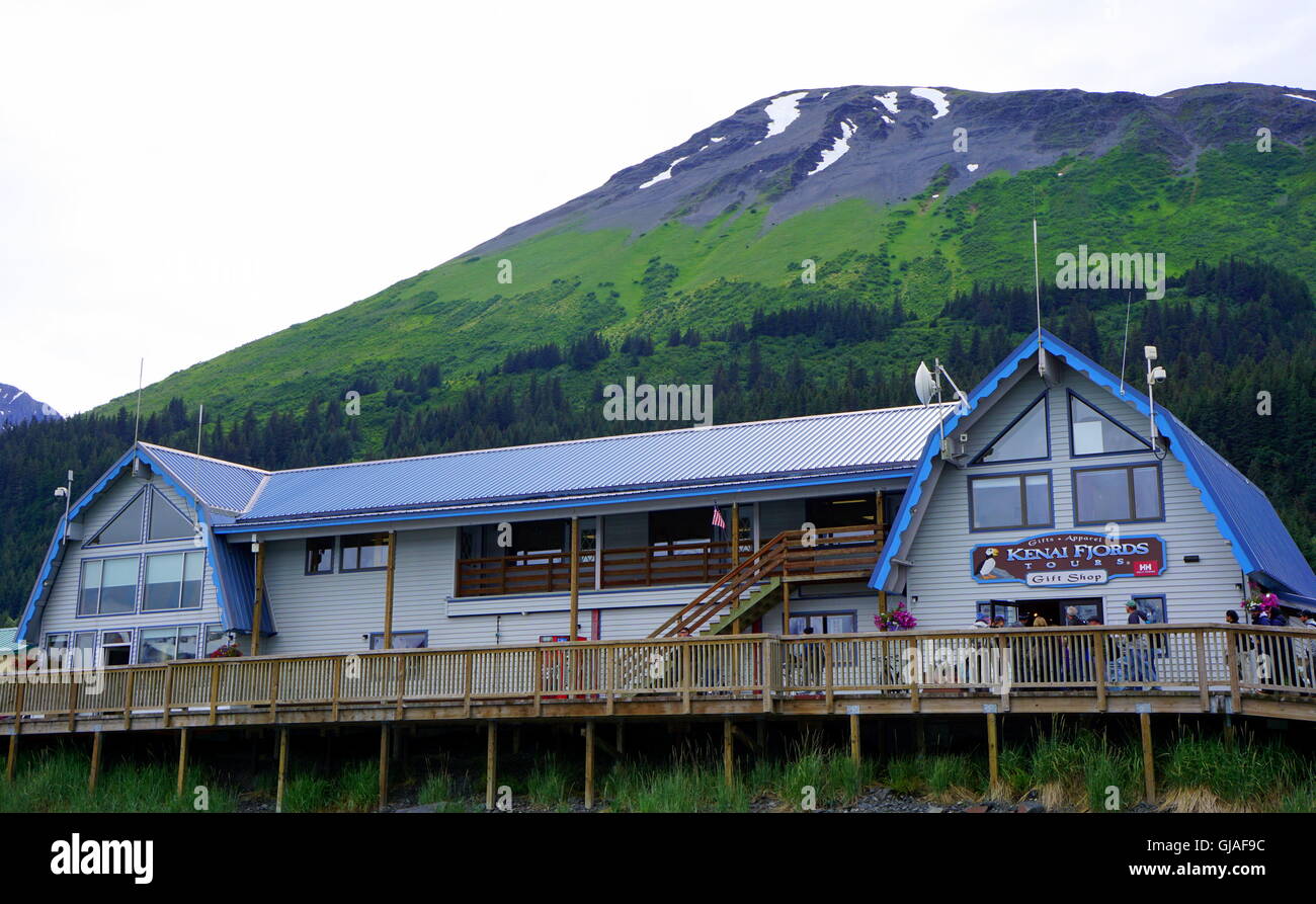 Memorizza sul lungomare presso la piccola barca del porto con lo sfondo di foresta verde e blue ice mountain, Seward, Alaska, Stati Uniti d'America Foto Stock