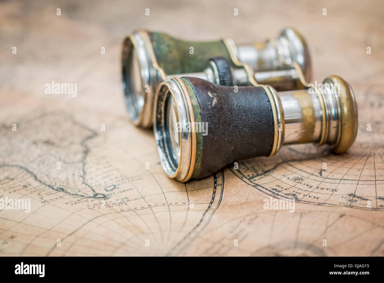 Coppia di vecchi binocolo su una mappa vintage, suggerendo di esplorazione o di viaggiare Foto Stock