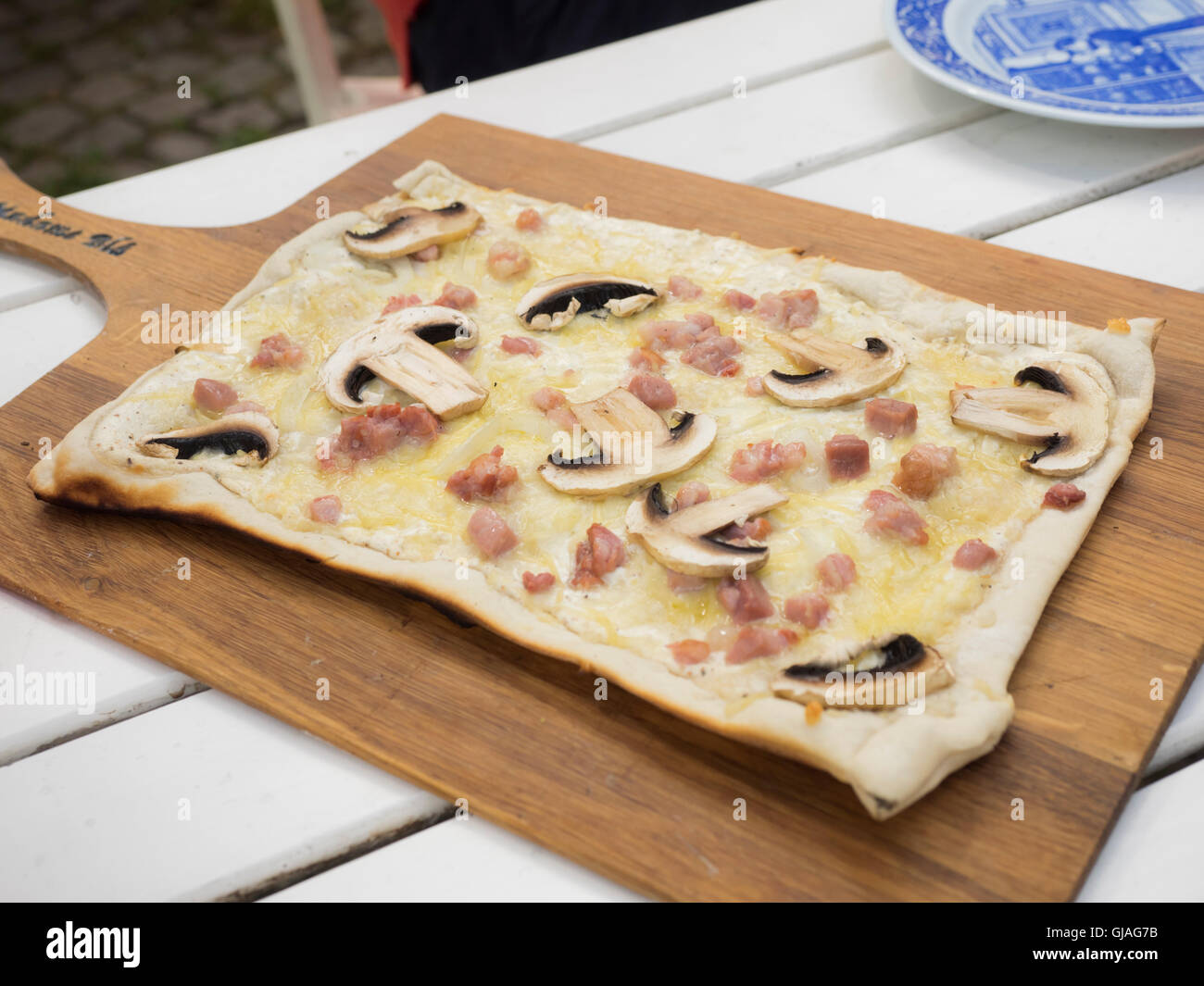 Un cucinato al momento tarte flambée su una tavola di legno. Foto Stock