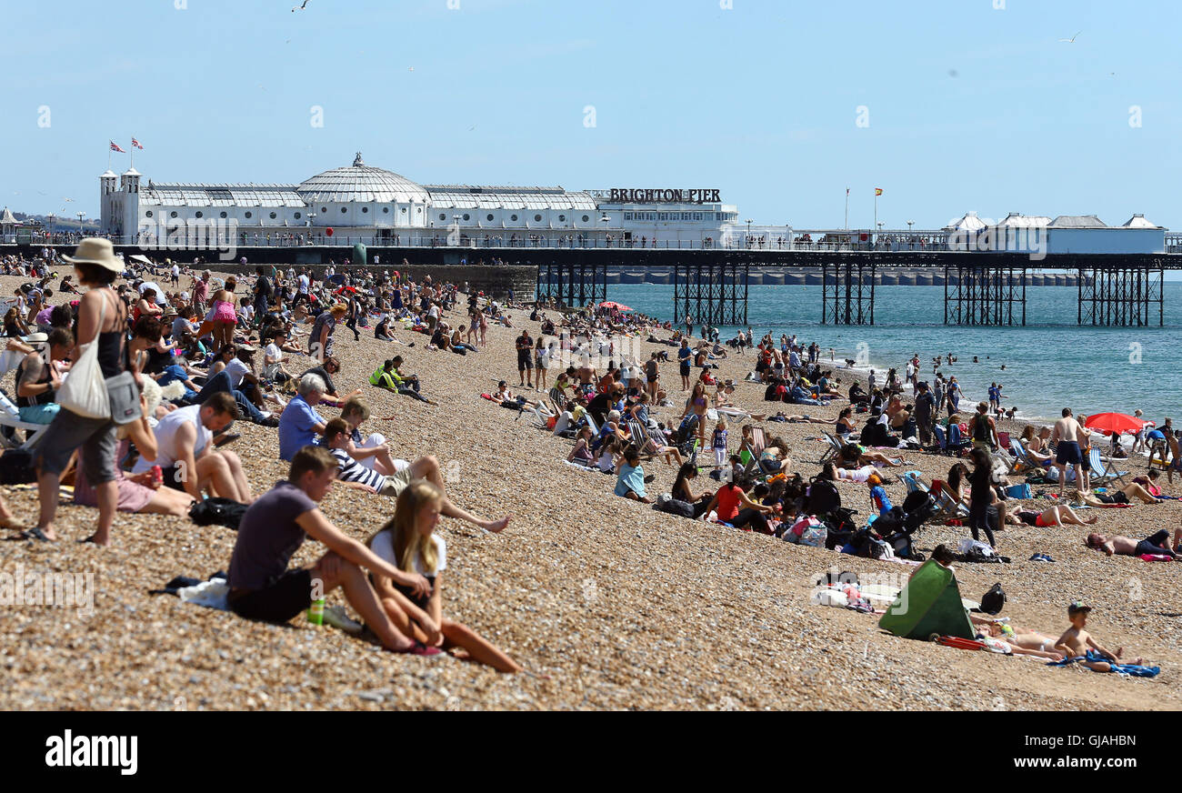 Le persone godono di un clima caldo e sulla spiaggia di Brighton, East Sussex, i britannici sono impostati per crogiolarsi in una tre-giorni di sunny scrivi come il mercurio sale ben al di sopra della media per questo periodo dell'anno. Foto Stock