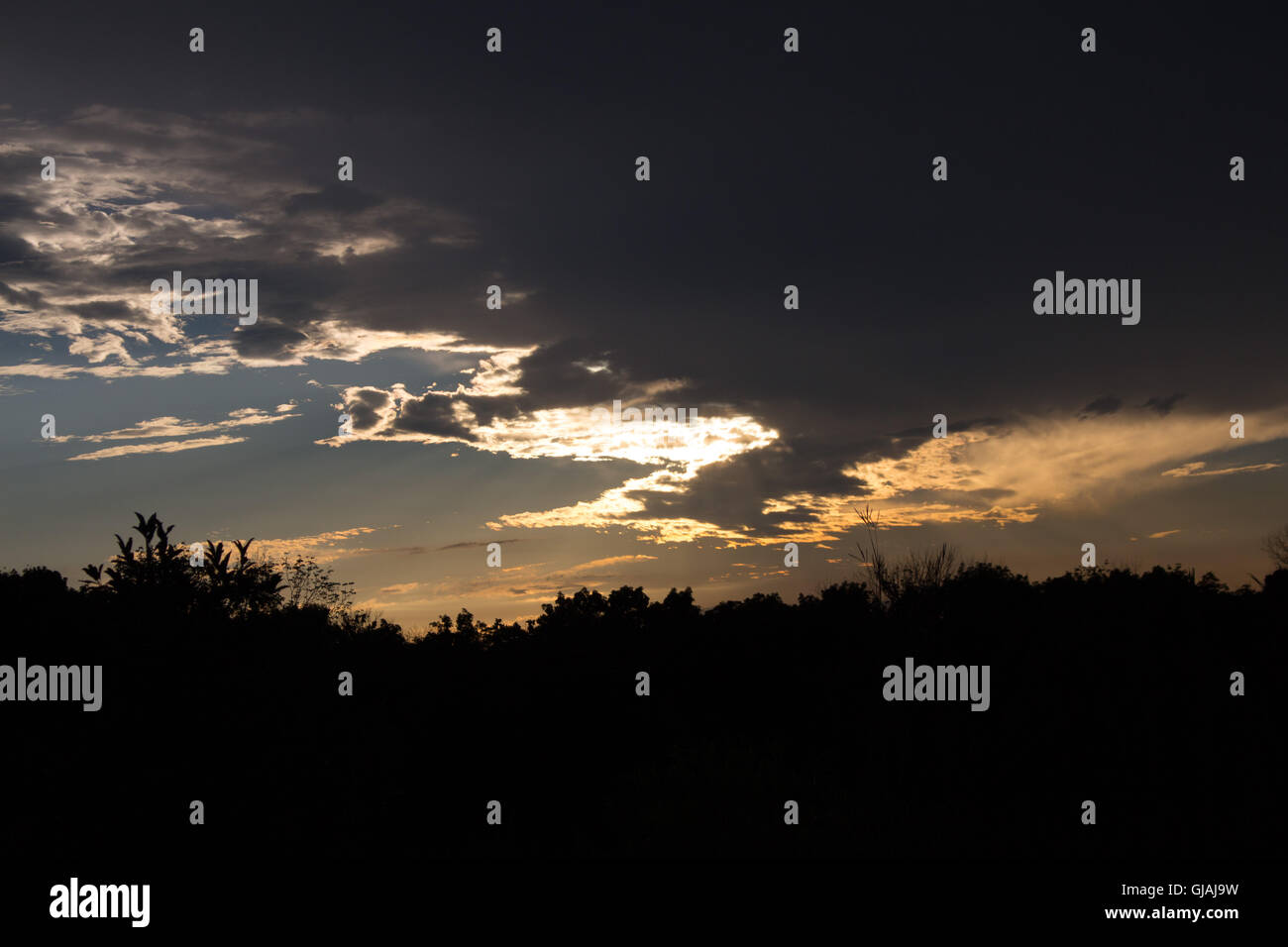 Sera luce del sole che filtra attraverso le nubi, creando un rivestimento in argento Foto Stock