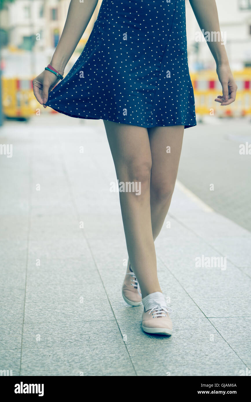 Gambe di bambina vestito con un abito corto e scarpe. Tonica foto Foto Stock