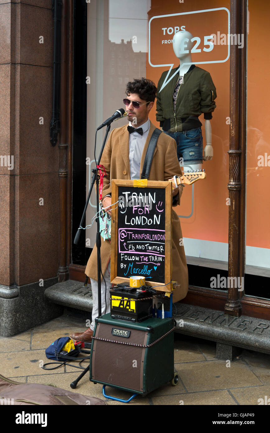 Un suonatore ambulante di eseguire su Princes Street, Edimburgo a raccogliere il denaro per il treno per Londra. Foto Stock