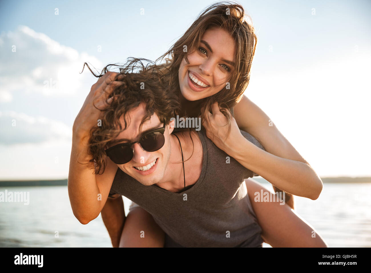 Giovani sorridenti matura in amore sovrapponibile in spiaggia Foto Stock