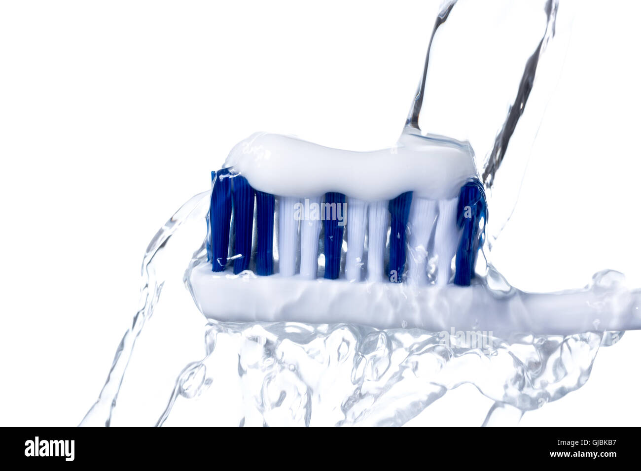 Spazzolino da denti con dentifricio sotto acqua corrente isolato su sfondo bianco, splash. Foto Stock