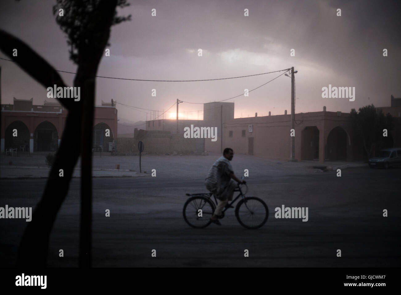 Silhouette, nativo dalle bicicle, nuvole di tempesta, atmosfera serale del Marocco, villaggio, tempesta, in viaggio Foto Stock