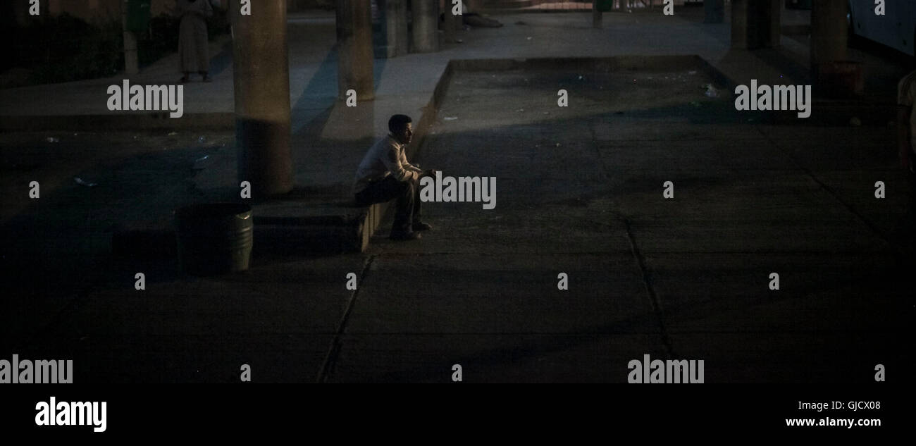 Lonesome man è in attesa sul bus stop al mattino presto,solitudine, espressione pensosa, Marocco Ouarzazate Foto Stock