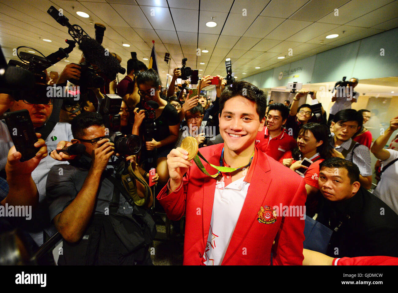 Singapore. Il 15 agosto, 2016. Singapore è oro medaglia Giuseppe scolastico (C) in posa per una foto tenendo in mano la sua medaglia d'oro a Singapore Changi Airport, 15 agosto 2016. Singapore il primo campione olimpionico Giuseppe scolarizzazione ritorna in trionfo dal brasiliano di Rio de Janeiro dopo il tifo la nazione con una medaglia d'oro in uomini 100m Butterfly finali su Sabato. © poi Chih Wey/Xinhua/Alamy Live News Foto Stock