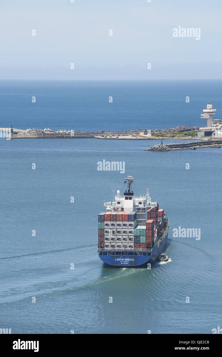 Keelung, Taipei, Taiwan. 16 Ago, 2016. Nave container di Lantau Breeze è guidato fuori del porto di Keelung, accompagnato da un rimorchiatore. La nave ha fatto un arresto del carico a Keelung durante un viaggio da Nagoya, Giappone Taiwan il contenitore più grande porto di Kaohsiung. Keelung Porto di Taiwan è il porto più settentrionale e gestisce più di dodici milioni di tonnellate di merci al mese. © Craig Ferguson/ZUMA filo/Alamy Live News Foto Stock