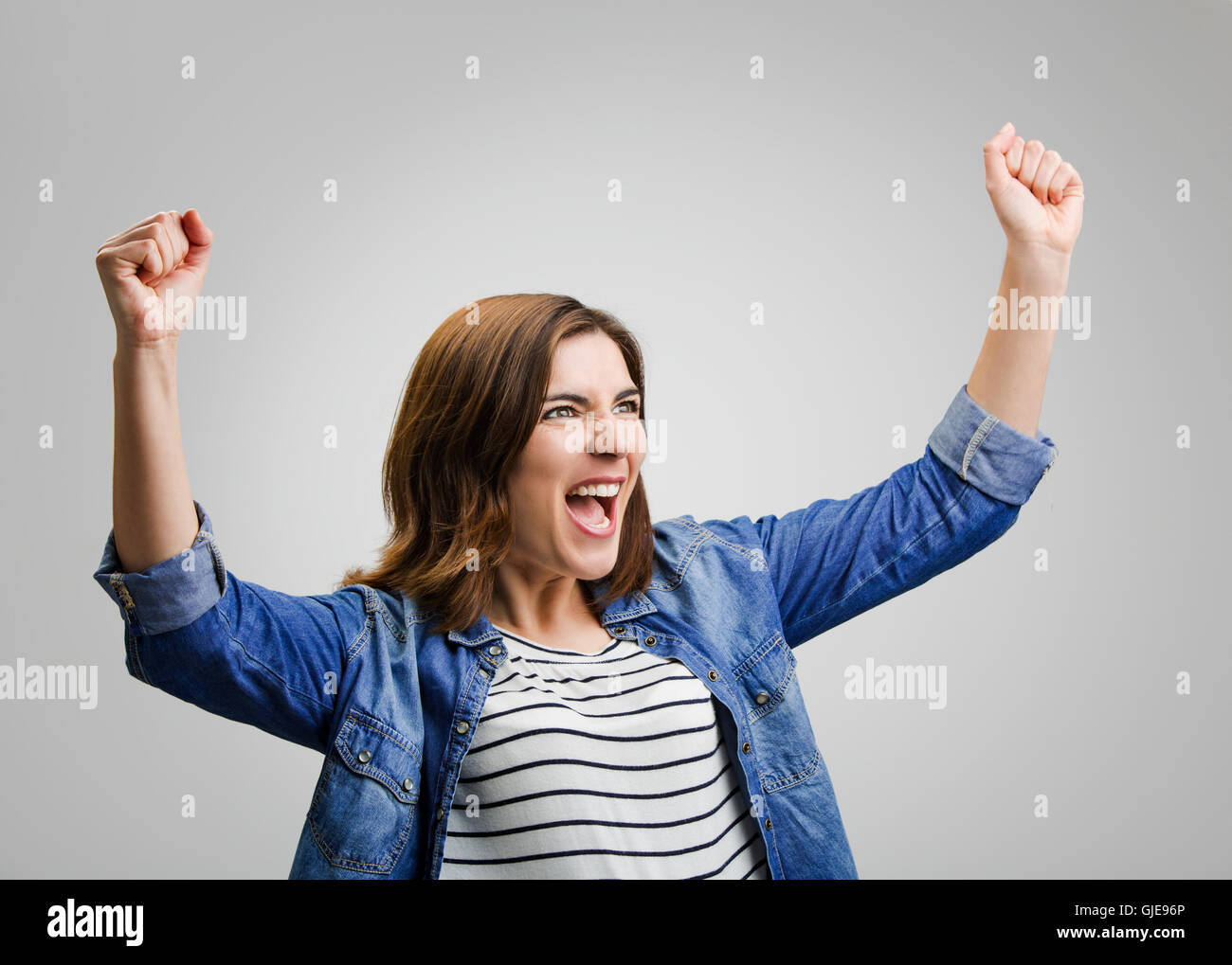 Studio ritratto di una donna di successo con le braccia sollevate Foto Stock