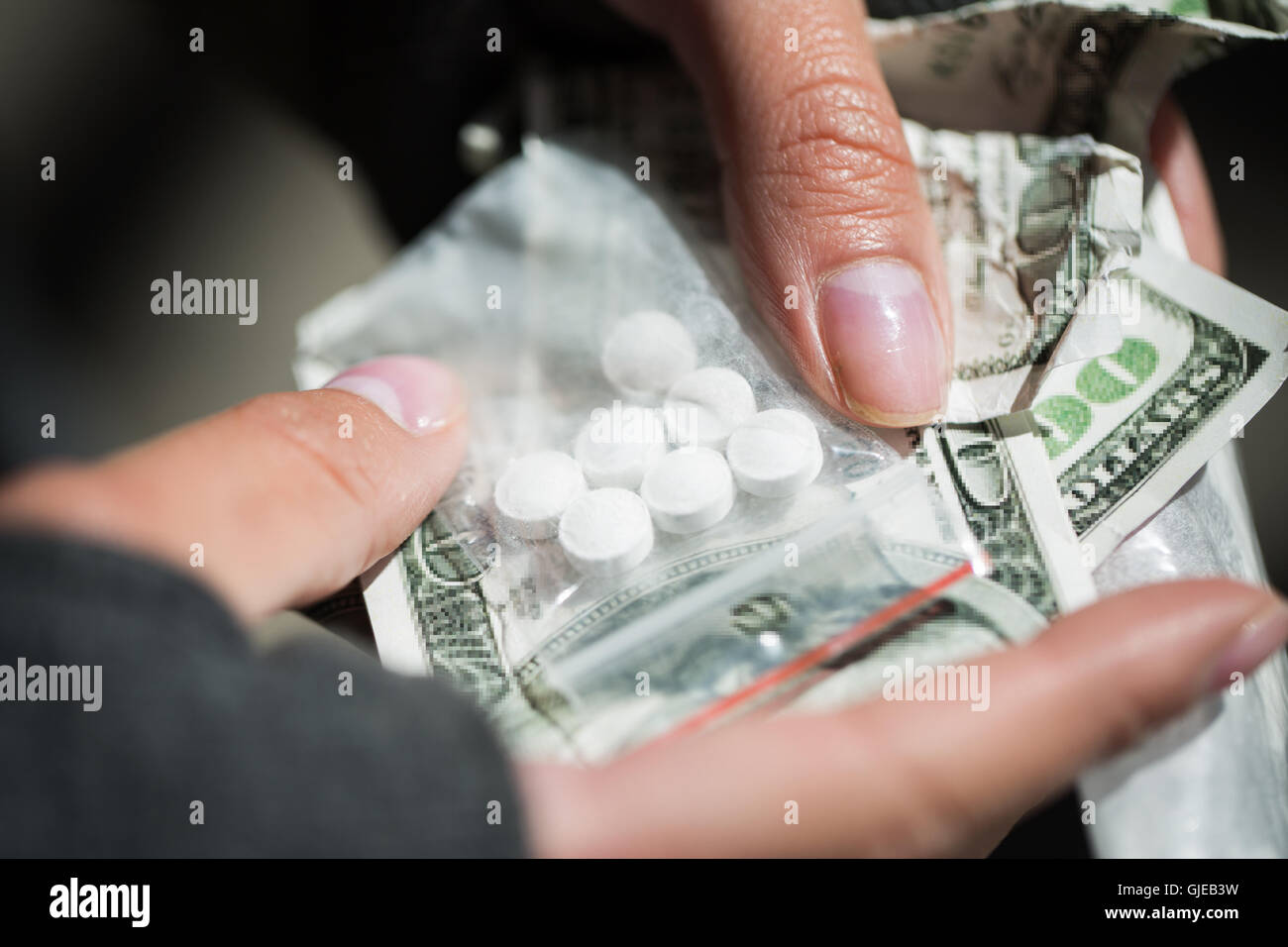 Close up addict le mani con la droga e denaro Foto Stock