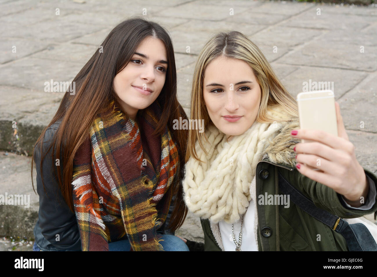 Ritratto di due giovani amiche tenendo selfie con lo smartphone su un viaggio insieme. Il concetto di turismo. All'esterno. Foto Stock