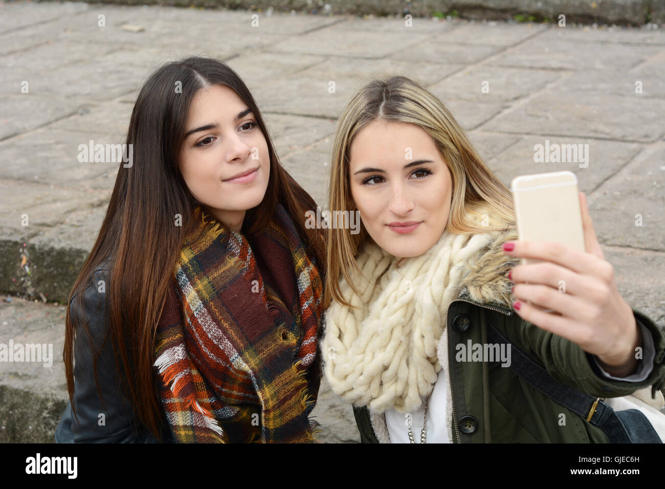 Ritratto di due giovani amiche tenendo selfie con lo smartphone su un viaggio insieme. Il concetto di turismo. All'esterno. Foto Stock
