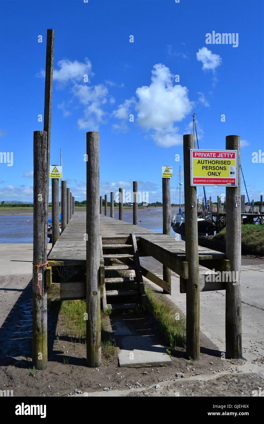 Planked in legno jetty con cartelli di avvertimento sul fiume Wyre a Skippool Creek cantiere, LANCASHIRE REGNO UNITO Foto Stock