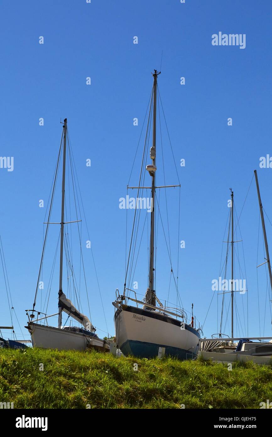 Blu e bianco Yacht scafi e alberi in bacino di carenaggio di Skippool Creek Foto Stock