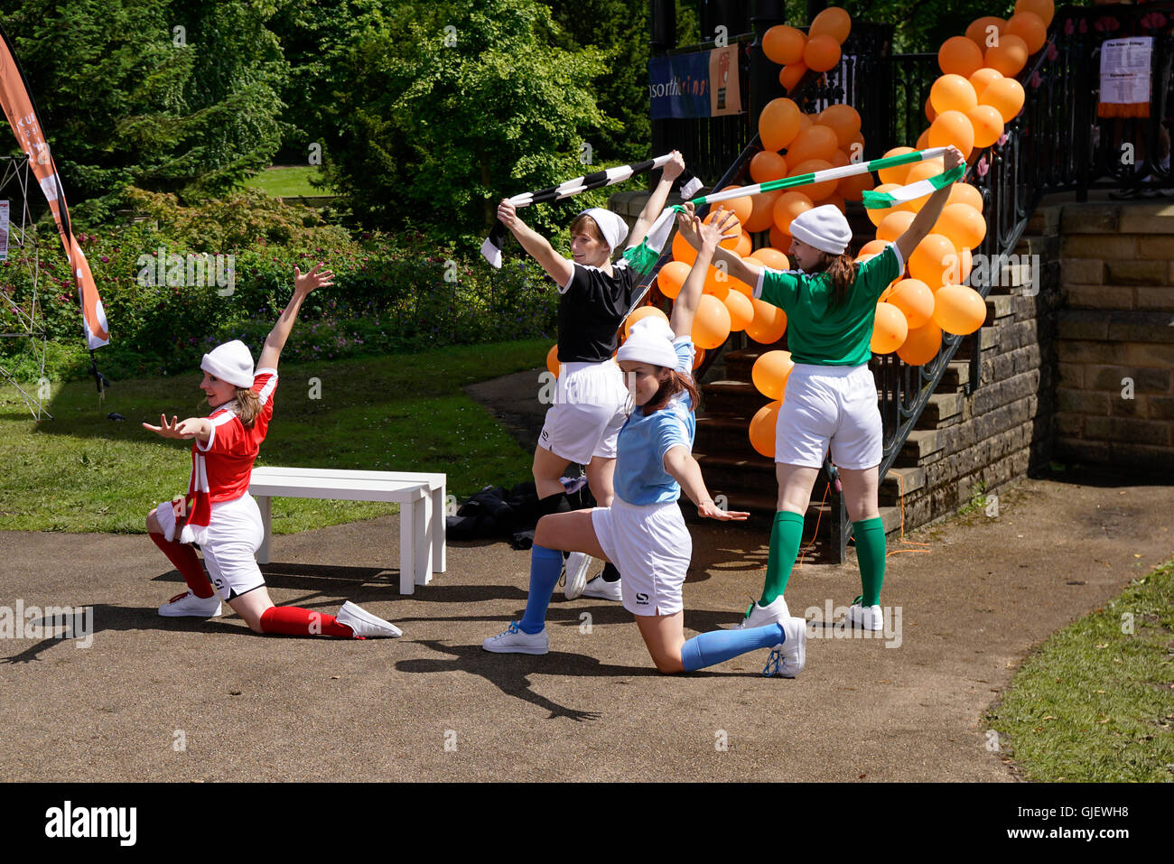 Un gruppo di ragazze di eseguire la routine di danza vestito in kit calcio in Buxton Peak District DERBYSHIRE REGNO UNITO Foto Stock