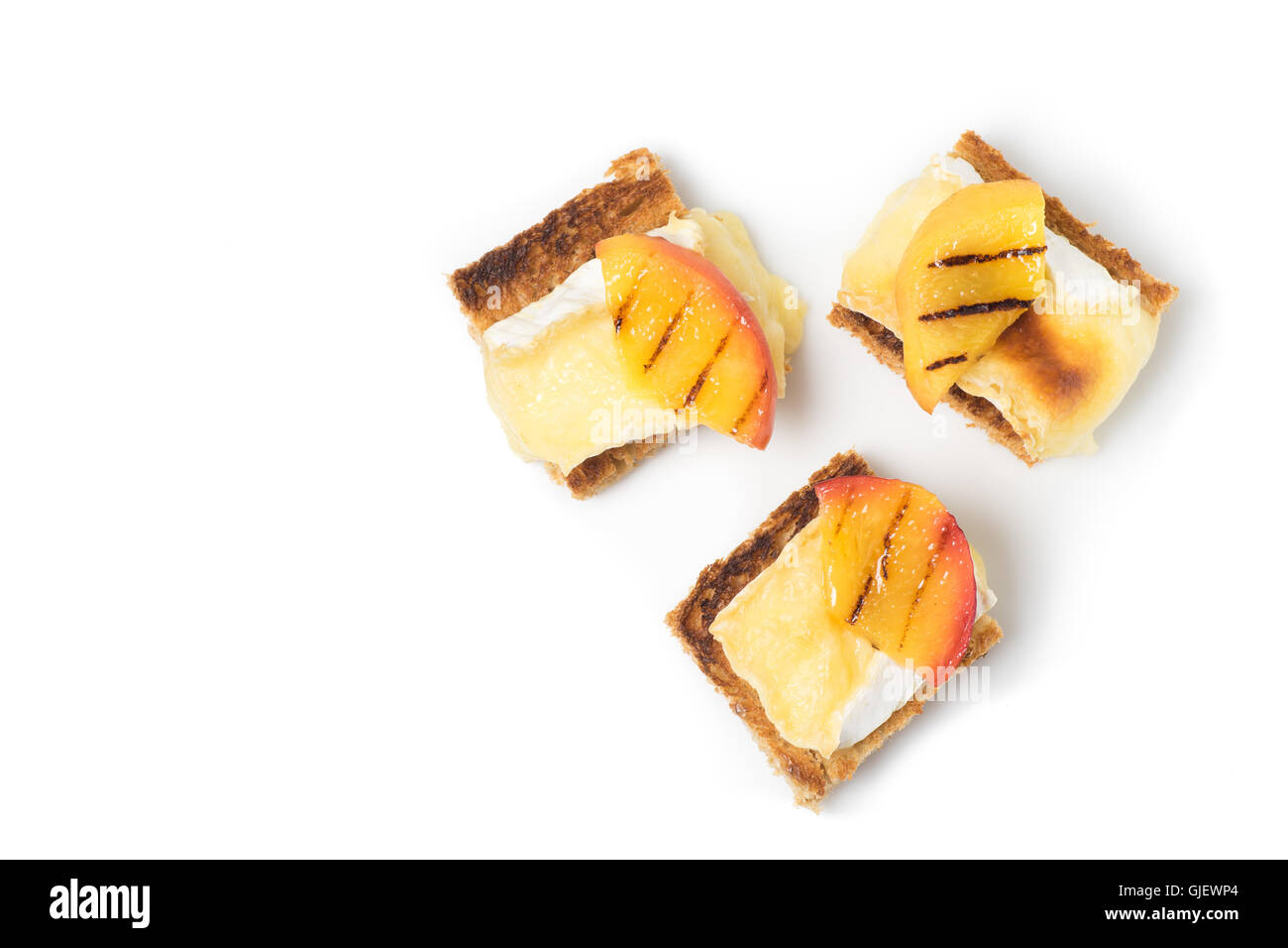 Crostini, antipasto con grigliate di brie e pesche noci piastrate isolato su bianco Foto Stock