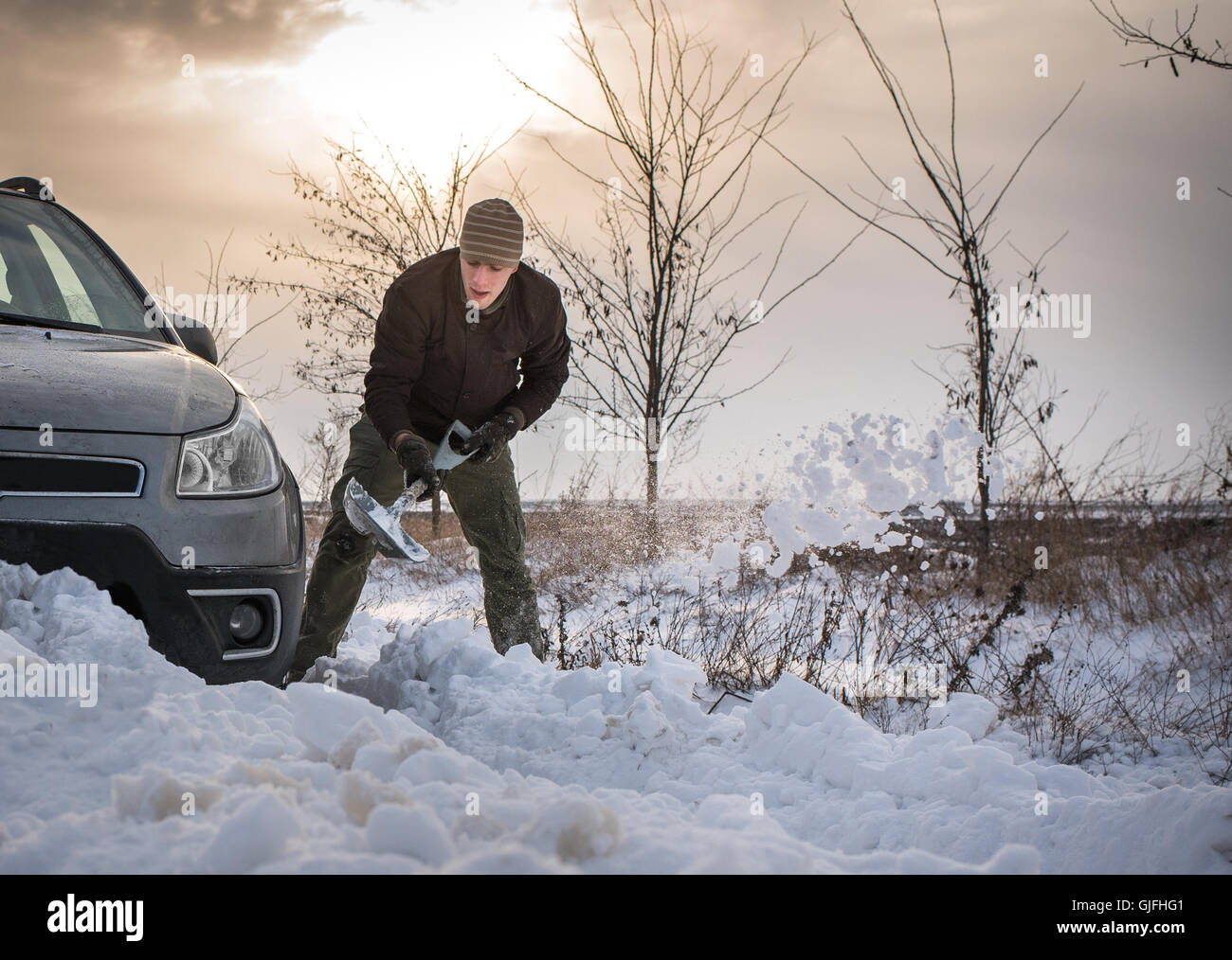 L uomo lo scavo fino bloccato in snow car Foto Stock