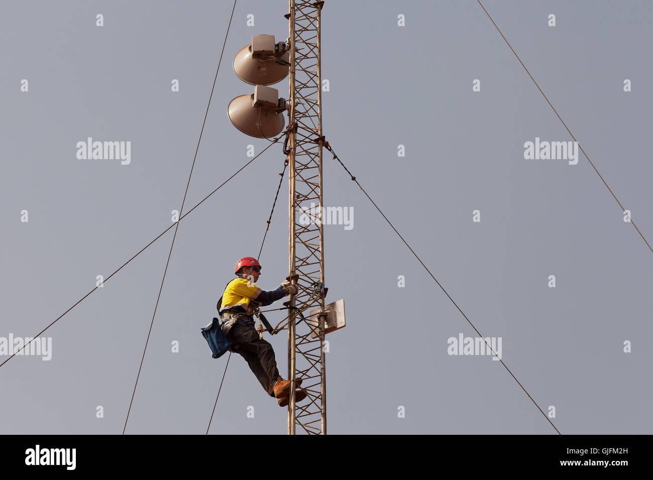 Miniera di ferro in Sierra Leone. Ingegnere delle Telecomunicazioni fino torre lavoro in altezza sulla radio a microonde di collegamento di rete di antenna di regolazione allineamento, ecc. Foto Stock
