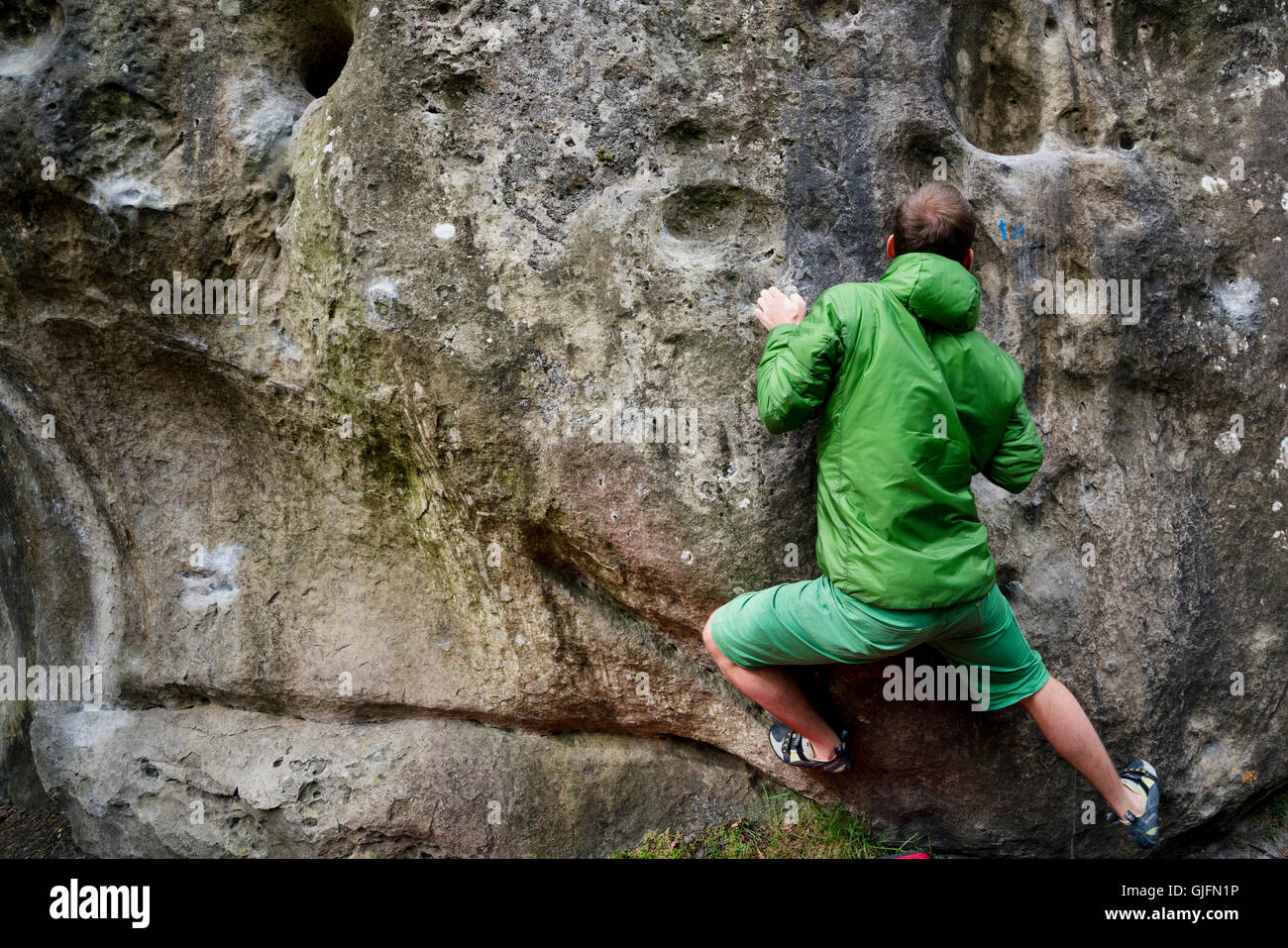 Un uomo bouldering, o di arrampicata su roccia, a Fontainebleau, Francia. Foto Stock