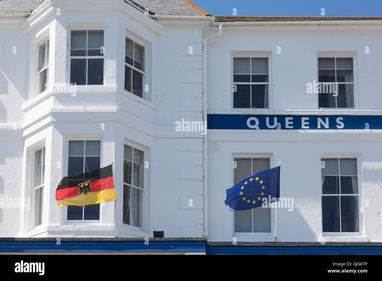 Bandiera UE e bandiera tedesca di fronte al Queens Hotel in Penzance, Cornwall, Regno Unito. Foto Stock