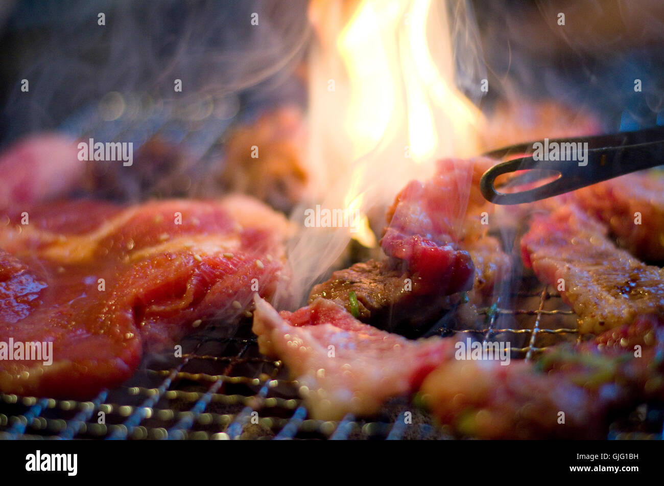 Sottili fette di carne di maiale e manzo su uno stile Coreano barbecue. Foto Stock