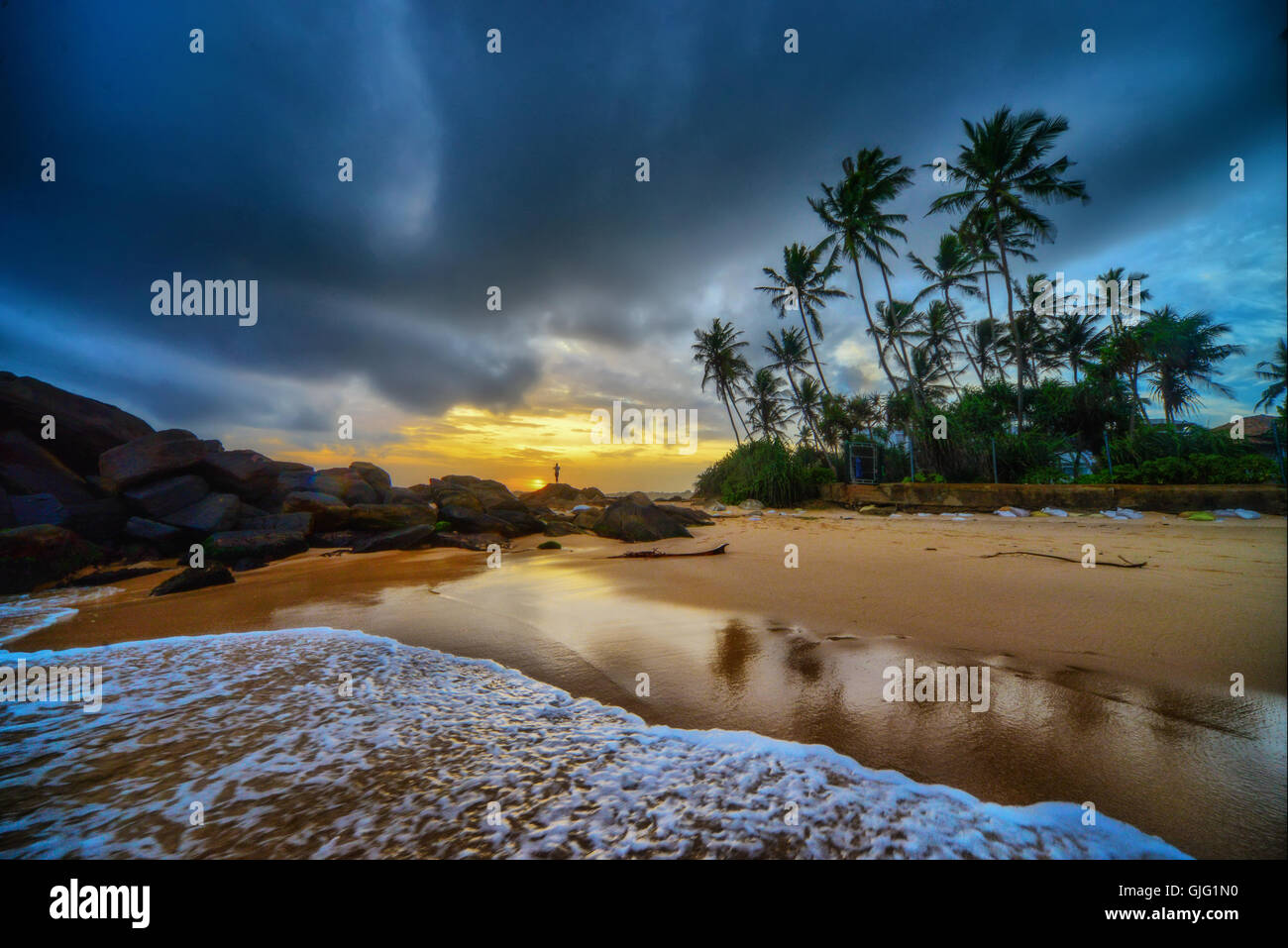Piccole onde che si infrangono sulla spiaggia tropicale al tramonto Foto Stock