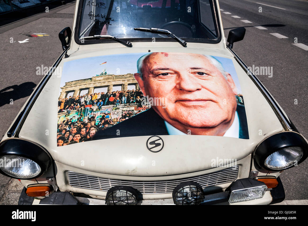 Dettaglio di una vecchia Trabant vettura con un'immagine di Mikhail Gorbaciov e la caduta del muro di Berlino sul cofano, Berlino, Germania. Foto Stock