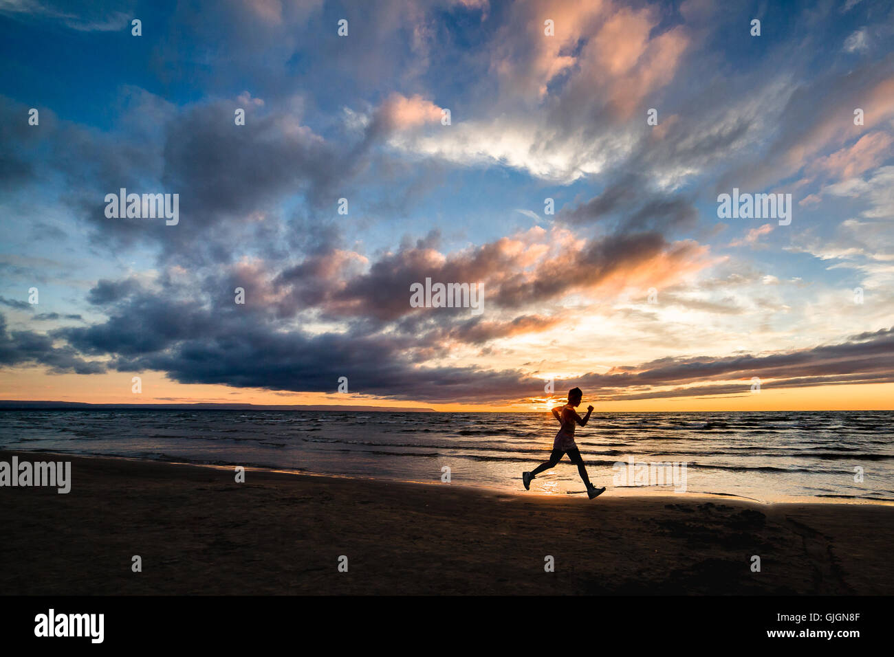 Runner su jogging su una spiaggia deserta. Foto Stock