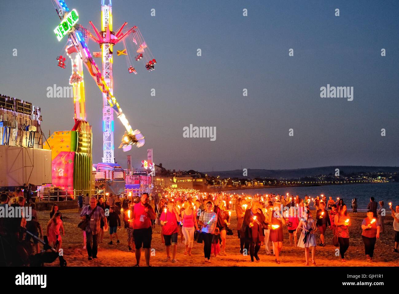 Weymouth. Dorset, Regno Unito. 16 Ago, 2016. Dopo una torrida giornata sulla spiaggia centinaia di prendere parte a una serata fiaccolata lungo Weymouth spiaggia sabbiosa. La processione organizzata dal Weymouth Il Carnevale è stato organizzato come un omaggio a assente cari. Presidente di carnevale, Ryan speranza, ha detto, "Siamo orgogliosi di essere il supporto del Weldmar Ospizio fiducia attraverso questo evento" Credito: Tom Corban/Alamy Live News Foto Stock